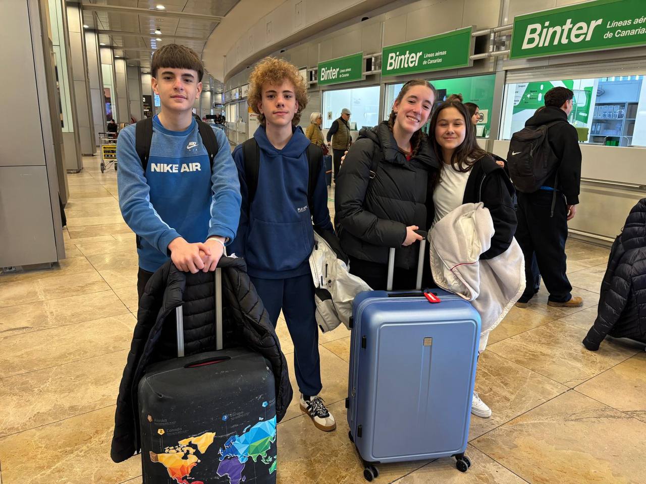 Cuatro estudiantes del Colegio JABY con maletas en el aeropuerto para su movilidad Erasmus Plus a Francia.